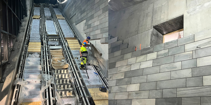 Bilden visar rulltrappor och en vägg med ljusgrå skiffer.