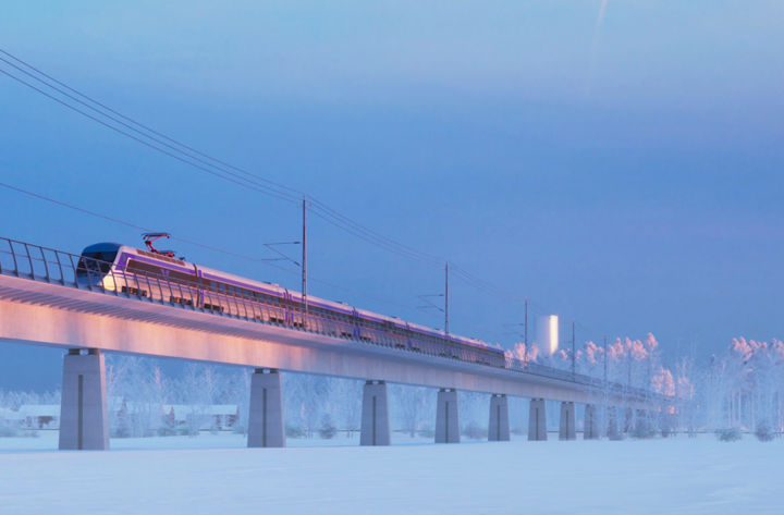 Tåg över bro i vinterlandskap