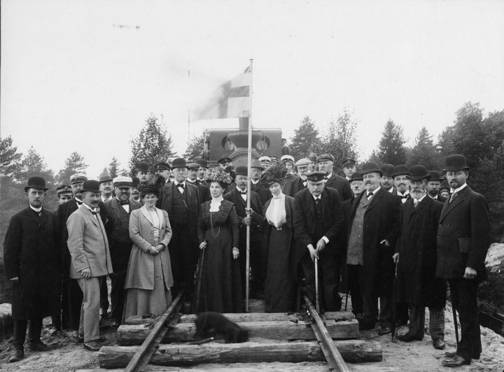 En grupp människor som står uppställda på ett järnvägsspår.