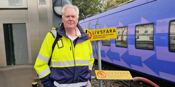 Göran Holmberg står framför en skylt med texten Livsfara.