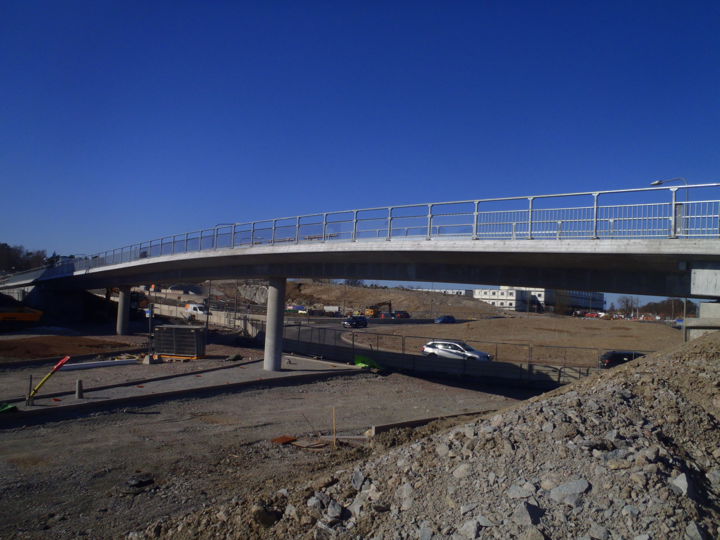 Bilden visar en gång- och cykelbro ovanför bilväg.