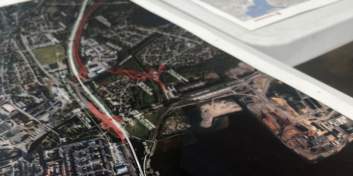 närbild på karta i grönt och blått, järnvägen illustreras i en vit linje