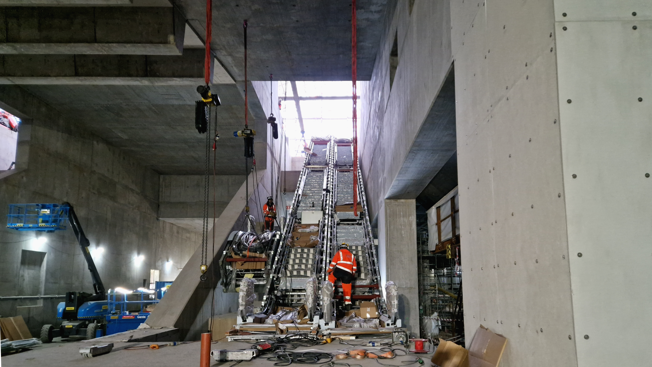 Bild på stationsutrymmet. Två rulltrappor är monterade och en till håller på att monteras.