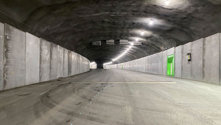 Tunnel med väg, allt i grått, förutom nödutgång i grönt.