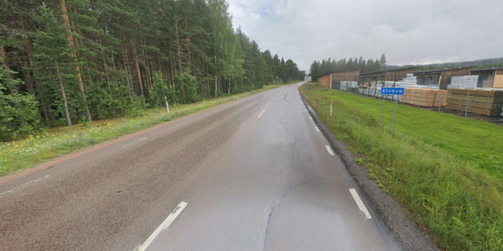 Väg 87 som passerar SCA till höger samt en skylt som det står Stugun på. Skog till vänster i bild. Många gråa moln på himlen.