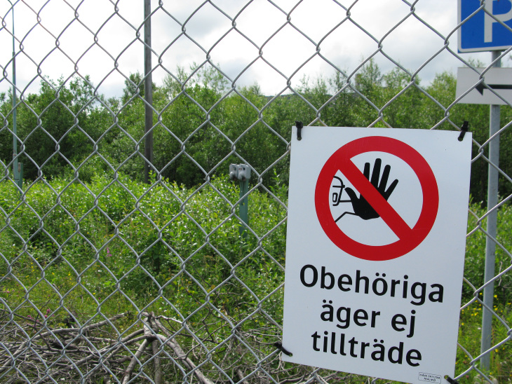 Skylt uppsatt på ett stängsel med texten att obehöriga äger ej tillträde.