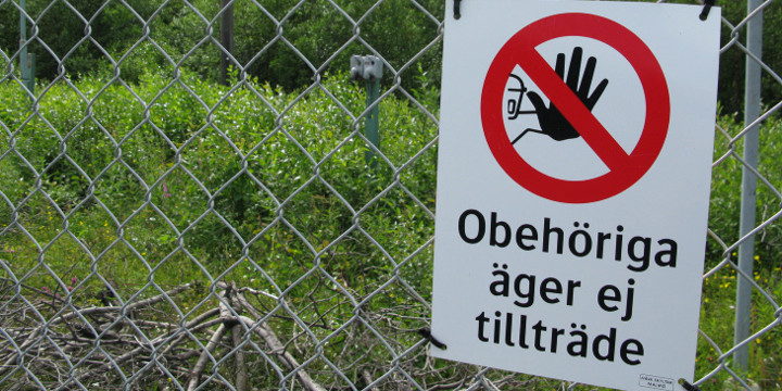 Skylt uppsatt på ett stängsel med texten att obehöriga äger ej tillträde.