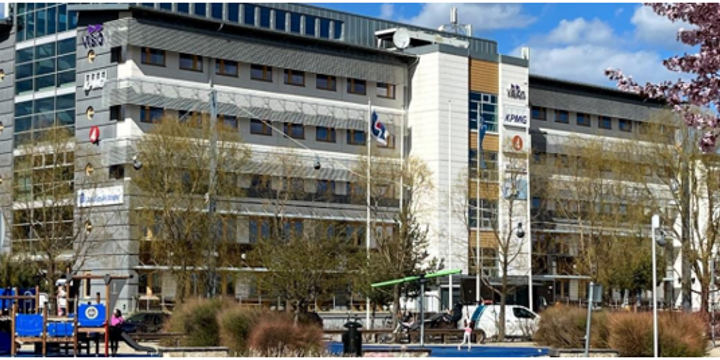 Kontorsfastigheten för det nya projektkontoret. Framför byggnaderna finns träd, buskar och en lekpark.