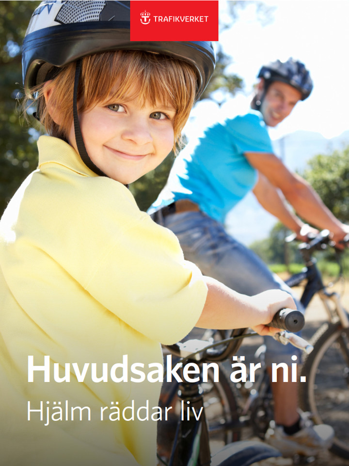 Barn med cykelhjälm, vuxen man i bakgrunden