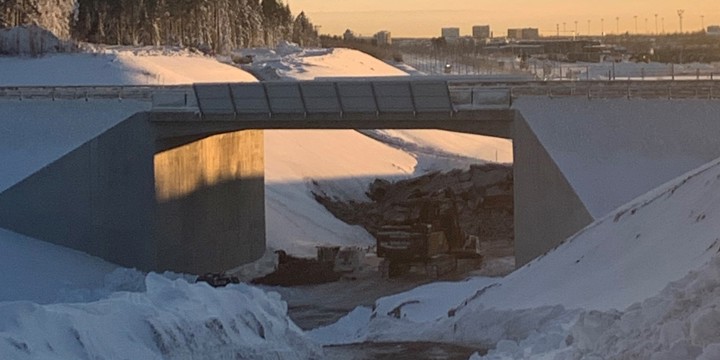 Bro i vinterlandskap i motljus