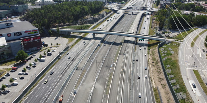 Bilden visar en gång- och cykelbro ovanför bilväg.