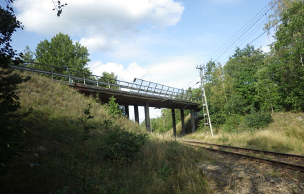 Bro över järnvägen, gröna träd vid sidan av järnvägen.