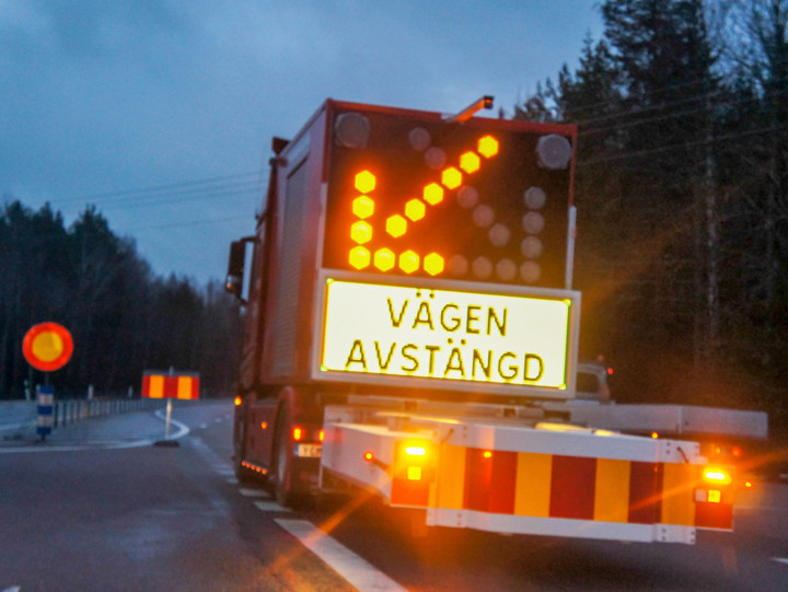 Beläggningsarbete pågår, på bilden syns ett TMA-fordon på vägen som visar att vägarbete pågår.