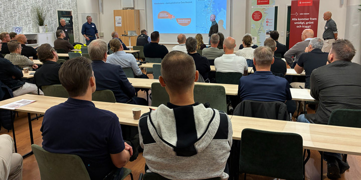 Ett konferensrum där flera sitter och lyssnar till en presentation.