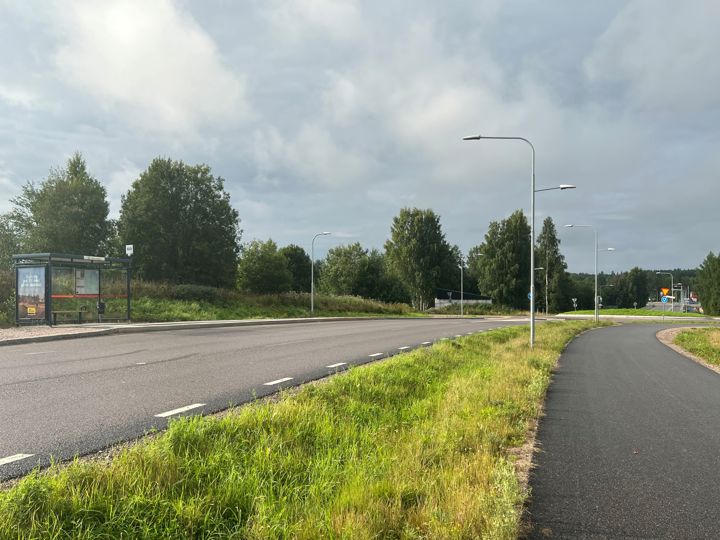 Busshållplats med väderskydd, den nya lokalvägen och en separerad gång- och cykelbanan intill vägen.