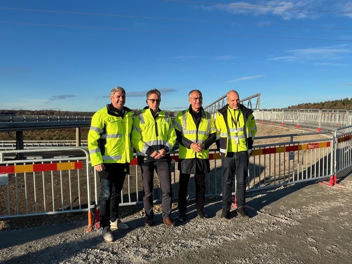 En grupp män framför nybyggd infrastruktur.