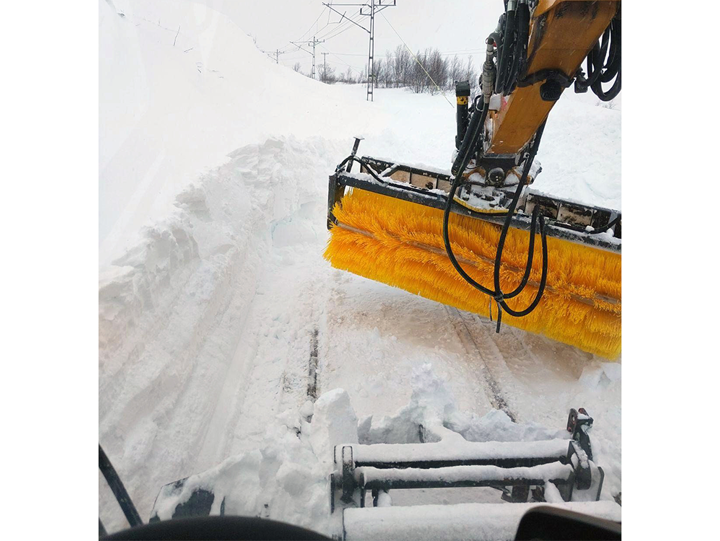 Räls som ligger mycket hög snö som snöröjs fram med maskin.