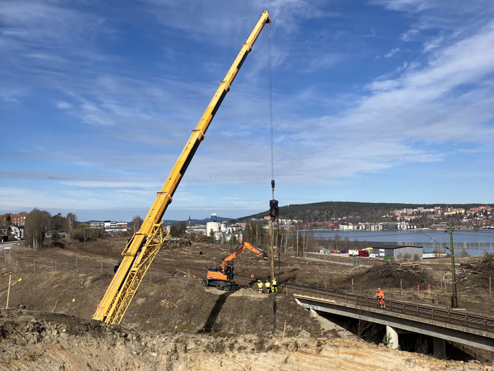 Spontarbeten vid Björneborgsgatan i samband med ett tågstopp 18 april 2026. Vid järnvägsbron över Björneborgsgatan står en hög byggkran. Kranen lyfter stålspont upp mot järnvägen där varselklädda arbetare står samt en grävmaskin.