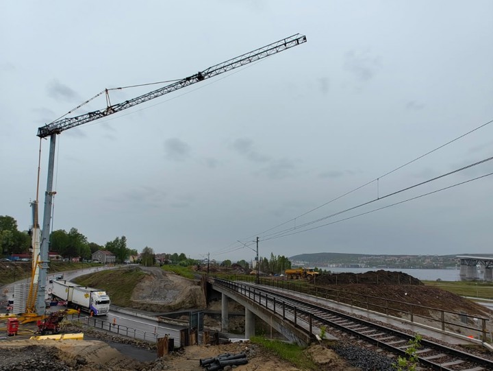 Spontarbeten vid Björneborgsgatan i samband med ett tågstopp 18 april 2026. Vid järnvägsbron över Björneborgsgatan står en hög byggkran. Kranen lyfter stålspont upp mot järnvägen där varselklädda arbetare står samt en grävmaskin.