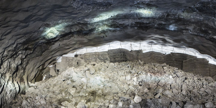 Tunnel med massor av nerfallna stenar och ljus genom öppningen ovan jord