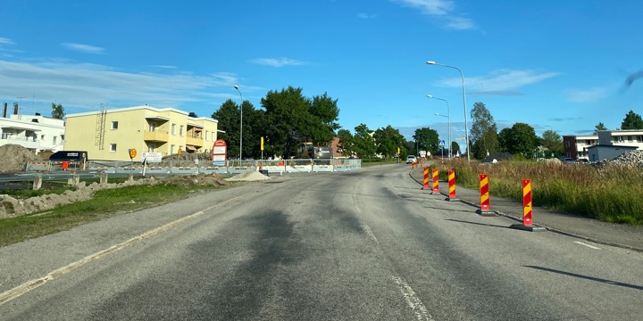 Centrumvägen i höjd med korsningen med Folketshusvägen. Vägskyltar, markeringsskärmar för sidohinder, längs vägen. Högar av jordmassor ligger längs vägen och ett arbetsområde är avspärrad med staket.